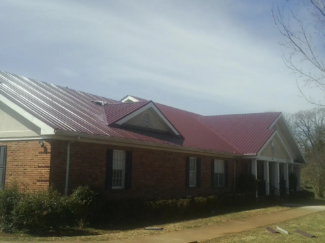 Red metal roof with gabled entries on a long brick building in Blairstown