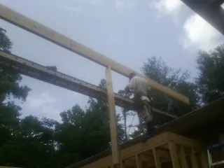 Carpenter setting a ridge beam over a new addition frame — Ice Dam Removal by Roofing Brothers in Blairstown